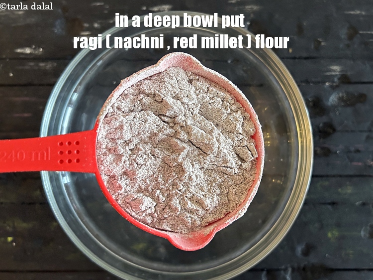 Step 5 – In a deep bowl put&nbsp;<meta charset="UTF-8" />1 cup&nbsp;<a href="glossary-ragi-flour-nachni-flour-nachni-ka-atta-red-millet-flour-1115i">ragi (nachni / red millet) flour</a>.