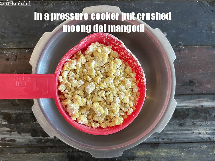 स्टेप 6 – प्रेशर कुकर में&nbsp;१ कप&nbsp;<a href=""https://www.tarladalal.com/glossary-crushed-mangodi-hindi-2346i"">क्रश की हुई तैयार मूँग दाल …