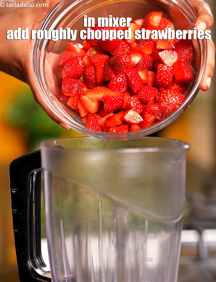 Step 3 – To make <strong>strawberry vanilla milkshake</strong>, In a mixer add 1&frac34; cups roughly <a href="https://www.tarladalal.com/glossary-chopped-strawberries-808i">chopped strawberries</a>.&nbsp;