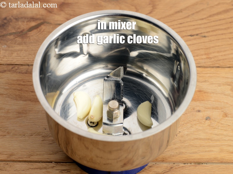 Step 4 – To make spice paste, in a mixer add 5 <a href="https://www.tarladalal.com/glossary-garlic-cloves-1857i">garlic (lehsun) cloves</a>.