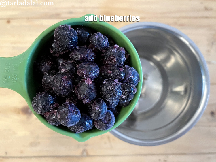 Step 7 – In a blender, put&nbsp;<meta charset="UTF-8" />1/2 cup&nbsp;<a href="glossary-frozen-blueberry-2552i">frozen blueberries</a>.&nbsp;