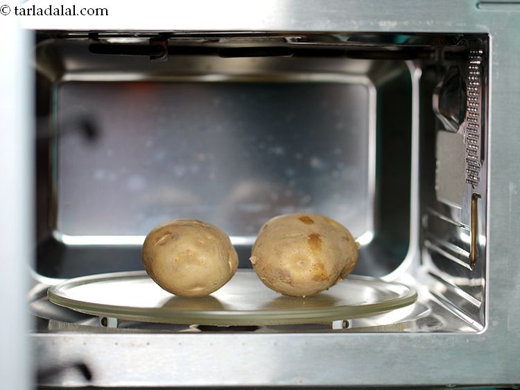 Step 4 – Place 2 whole large potatoes, with the skin, on the microwave turntable.
