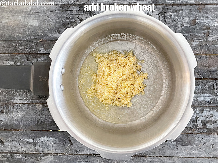 Step 22 – Add&nbsp;<!--%3Cmeta%20charset%3D%22UTF-8%22%20%2F%3E-->1/4 cup&nbsp;<a href="glossary-broken-wheat-dalia-bulgur-wheat-lapsi-fada-426i">broken wheat (dalia)</a>&nbsp;, washed and drained.
