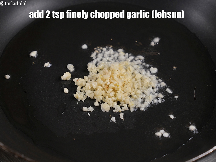 स्टेप 3 – तेल गरम होने पर लहसुन डालें।