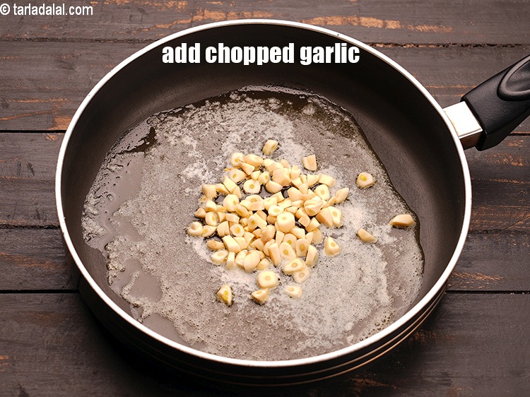 स्टेप 4 – २ टेबल-स्पून&nbsp;<a href=""https://www.tarladalal.com/glossary-chopped-garlic-hindi-790i"">कटा हुआ लहसुन</a>&nbsp;डालें ।