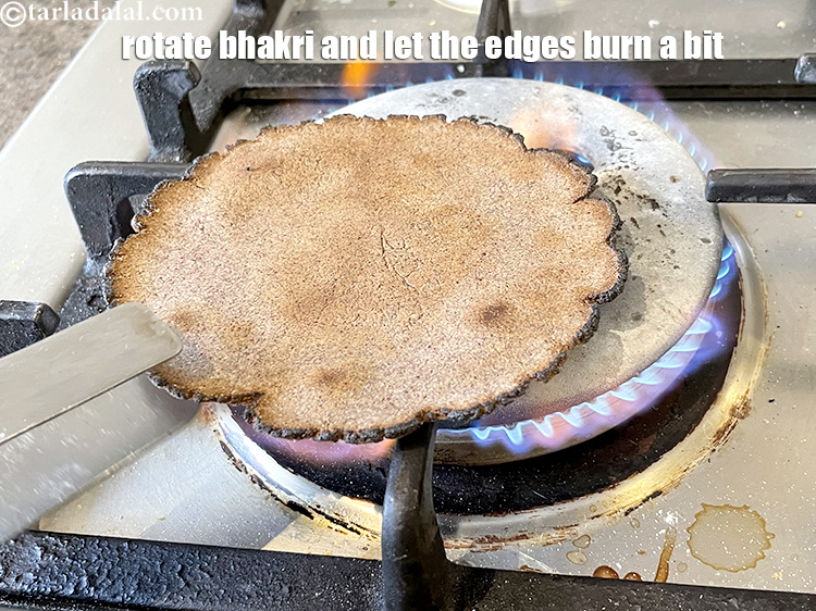 Step 32 – Remember to rotate the bhakri over the fire or keep flipping the bhakri to cook …