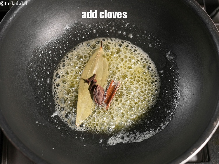 Step 23 – Add 2 <a href="https://www.tarladalal.com/glossary-cloves-laung-lavang-322i">cloves (laung / lavang)</a>.