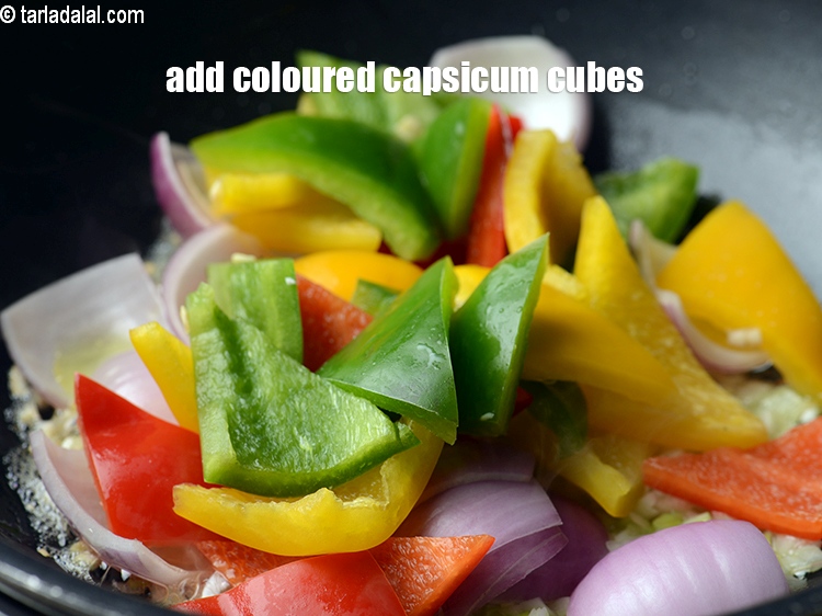 Step 23 – Add 1 cup triangular <a href="https://www.tarladalal.com/glossary-coloured-capsicum-cubes-2799i">coloured capsicum cubes</a>.