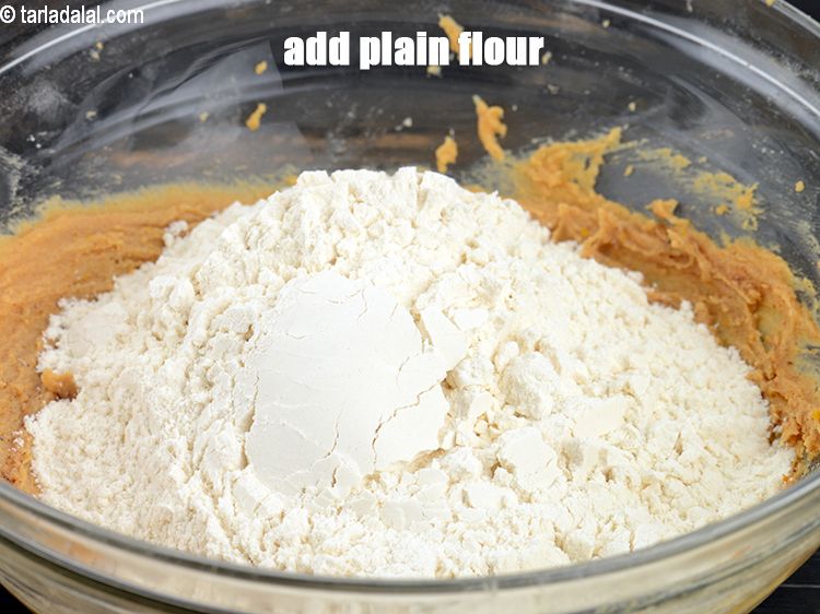 Step 22 – Add 1 &frac12; cups of&nbsp;<a href="https://www.tarladalal.com/glossary-plain-flour-maida-188i">plain flour (maida)</a>.