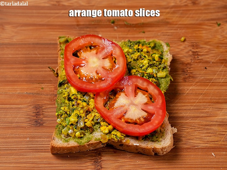 Step 22 – Arrange 2 <a href="https://www.tarladalal.com/glossary-tomato-slices-1823i">tomato slices</a>.