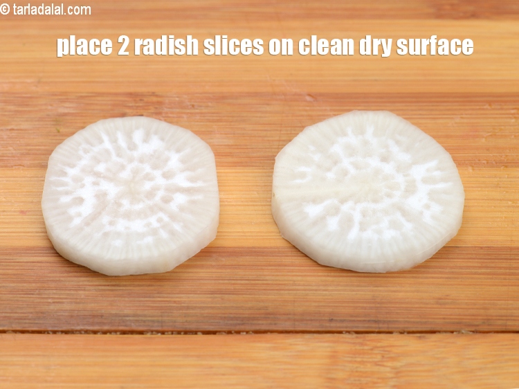 Step 23 – Place 2 <a href="https://www.tarladalal.com/glossary-radish-mooli-mula-muli-502i">radish (mooli)</a>&nbsp;slices&nbsp;on a clean and dry surface.