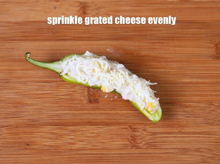 Step 21 – Sprinkle little <a href="https://www.tarladalal.com/glossary-grated-processed-cheese-868i">grated processed cheese</a> evenly over it.&nbsp;