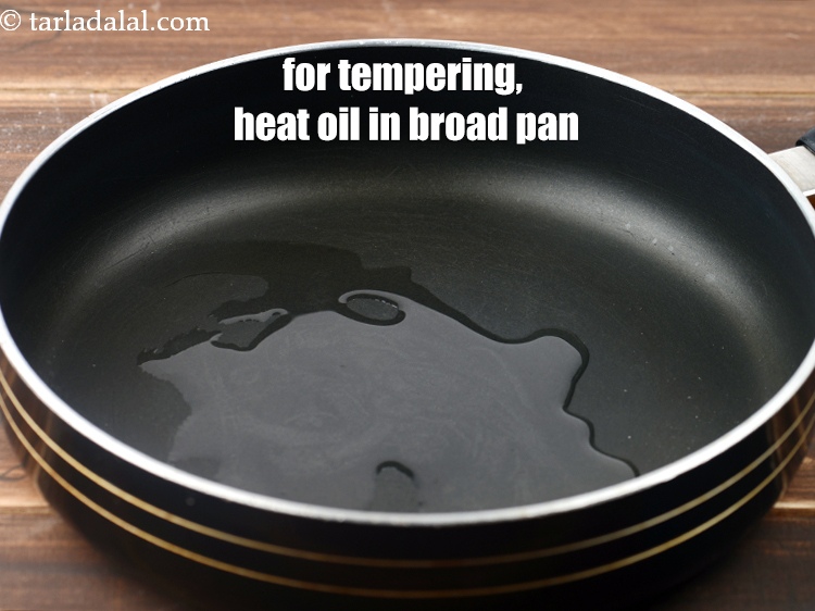 Step 22 – For the tempering, heat oil in a broad non-stick pan.