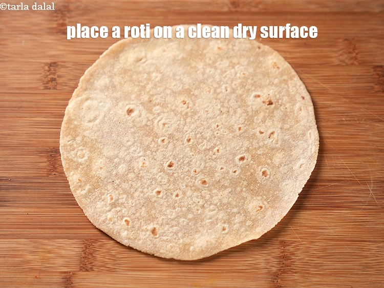 स्टेप 24 – एक चपाती को साफ सूखी सतह पर रखें।