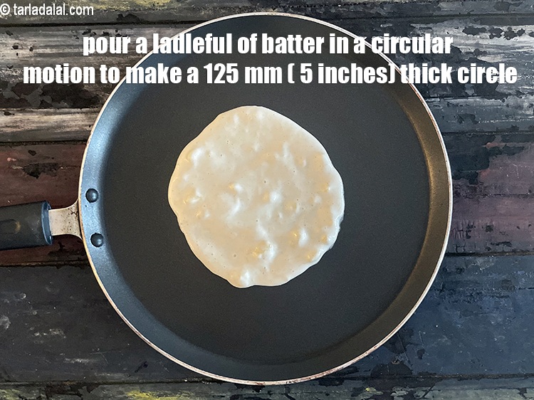 स्टेप 23 – एक करछुल घोल तवे पर डालें, गोलाकार में फैलाते हुए …