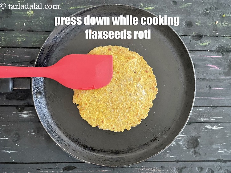 Step 25 – Press down with a spatula while cooking flaxseeds roti.