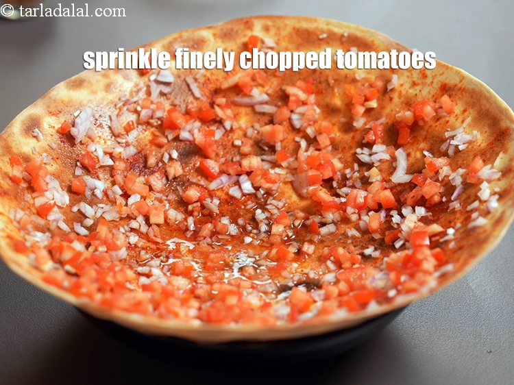 Step 23 – Sprinkle &frac14; cup finely <a href="https://www.tarladalal.com/glossary-chopped-tomatoes-779i">chopped tomatoes</a> evenly over it.