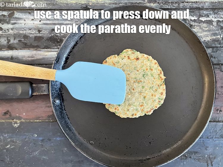 स्टेप 28 – पराठे को समान रूप से पकाने के लिए एक स्पैटुला …