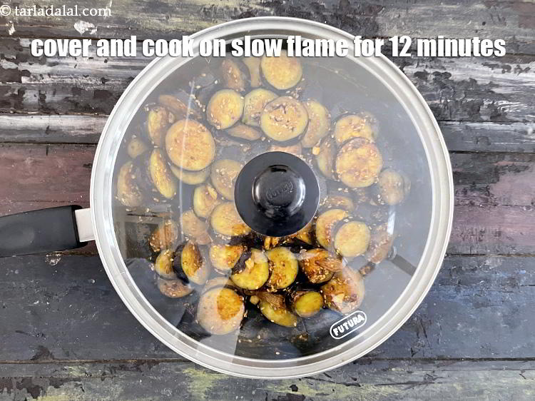 स्टेप 21 – ढककर धीमी आंच पर 12 मिनट तक या बैंगन के …
