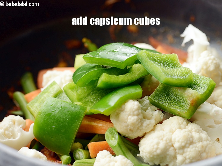 Step 23 – Add &frac12; cup <a href="https://www.tarladalal.com/glossary-capsicum-cubes-170i">capsicum cubes</a>.