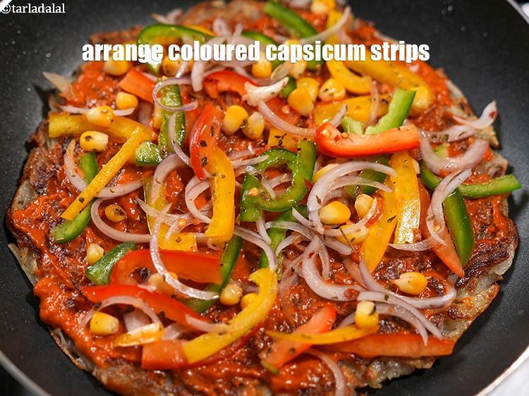Step 23 – Arrange &frac14; cup <a href="https://www.tarladalal.com/glossary-coloured-capsicum-strips-2802i">coloured capsicum strips</a>.
