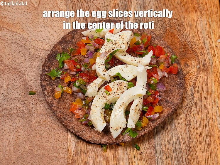 Step 24 – Arrange the egg slices vertically in the center of the roti.