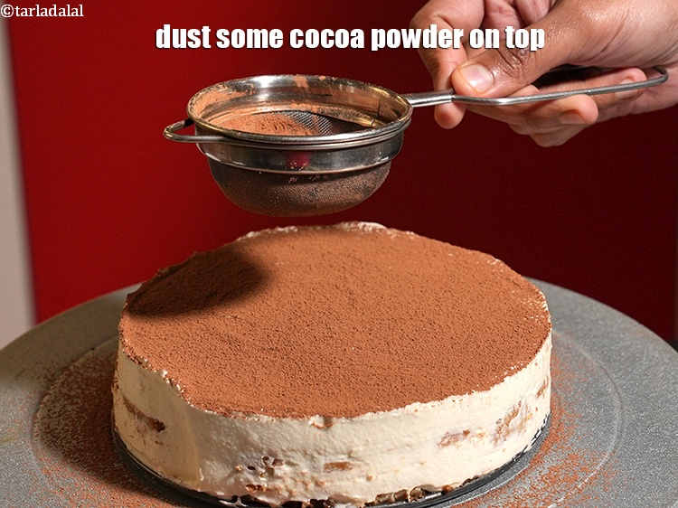 Step 22 – <p>Demould the cake carefully. Dust some <a href="https://www.tarladalal.com/glossary-cocoa-powder-284i">cocoa powder</a> on top.</p>