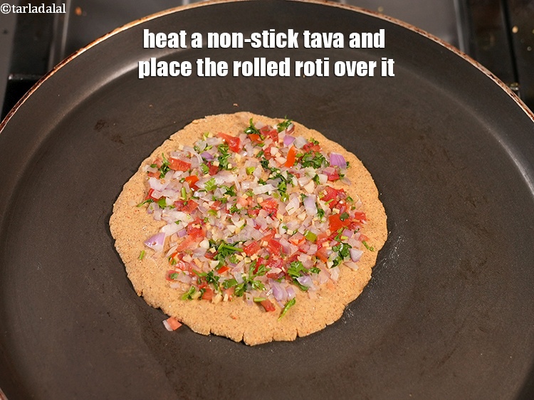 Step 24 – Heat a non-stick tava and place the rolled roti over it.