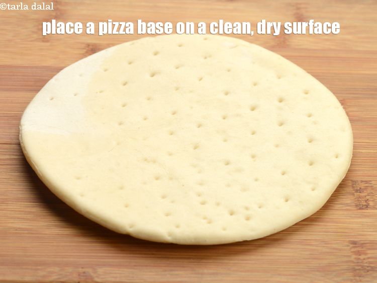 Step 25 – To make <strong>garlic and macaroni pizza</strong>, place a pizza base on a clean, dry surface.