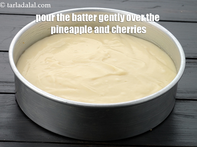 Step 23 – Pour the batter gently over the pineapple and cherries.