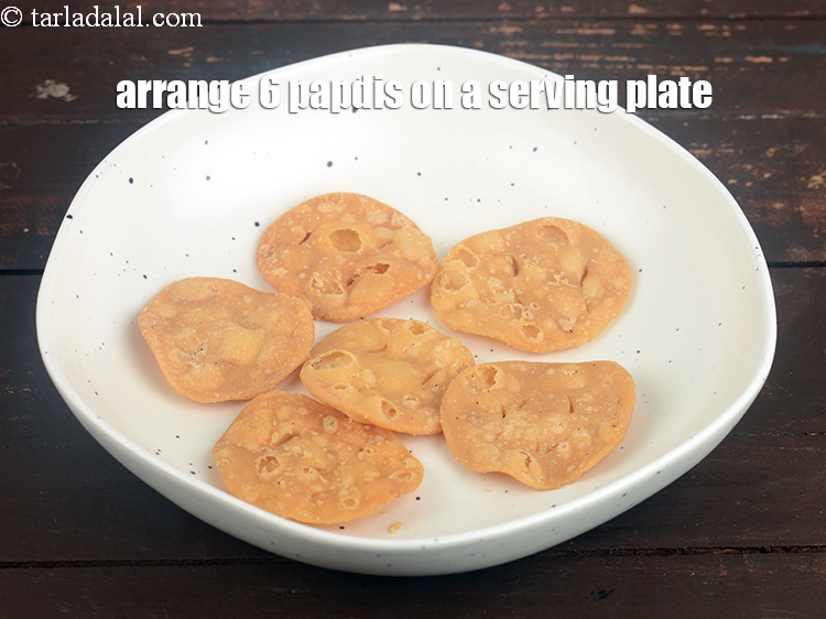Step 29 – Arrange 6 <a href="https://www.tarladalal.com/glossary-papdi-chaat-chaat-ki-puri-1999i">papdis</a>&nbsp;on a serving plate.