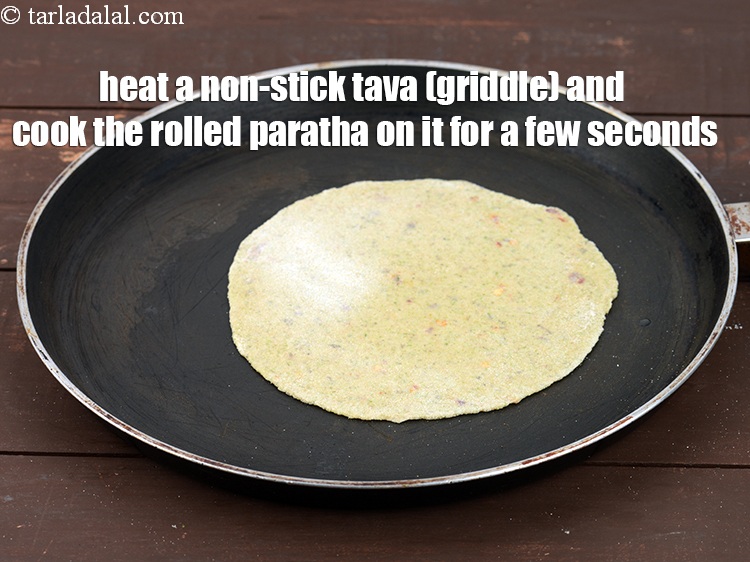Step 23 – Heat a non-stick tava (griddle) and place the rolled paratha on it. Cook it for …