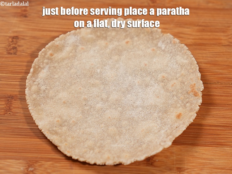 स्टेप 27 – परोसने से ठीक पहले पराठे को समतल, सूखी सतह पर …