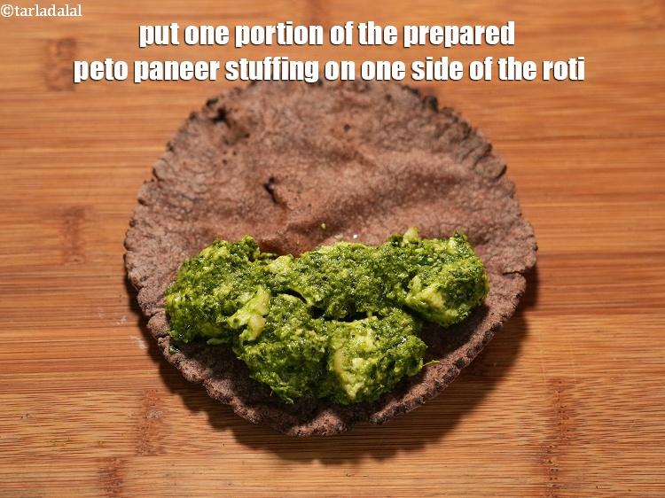Step 25 – Put one portion of the prepared peto paneer stuffing on one side of the roti.