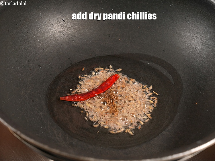 Step 24 – Add 1 dry <a href="https://www.tarladalal.com/glossary-pandi-chillies-pandi-dry-red-chillies-2373i">pandi chillies</a>.