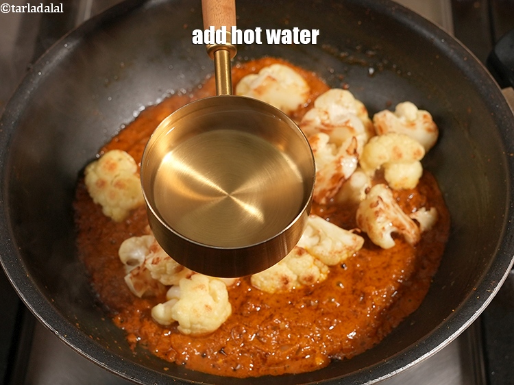 स्टेप 24 – 1/2 कप गरम पानी डालें।