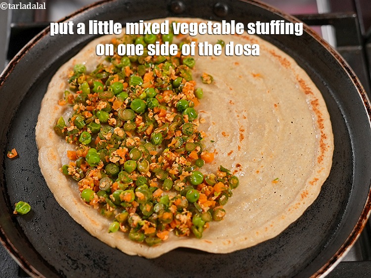 Step 24 – Put a little mixed vegetable stuffing on one side of the dosa.&nbsp;