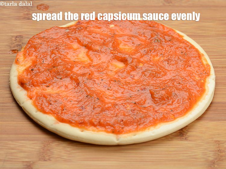 Step 26 – Spread &frac14; th of the red capsicum sauce evenly over it.