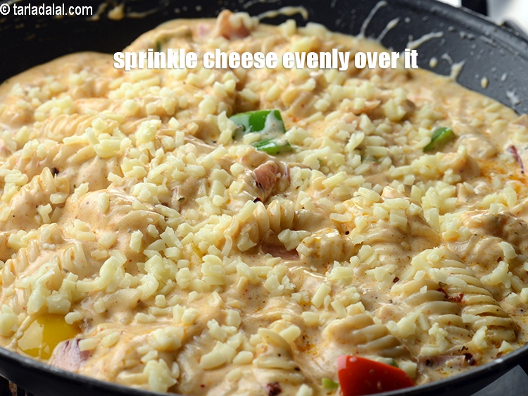 Step 26 – Sprinkle &frac14; cup <a href="https://www.tarladalal.com/glossary-diced-mozzarella-cheese-2805i">diced mozzarella cheese</a> evenly over it.