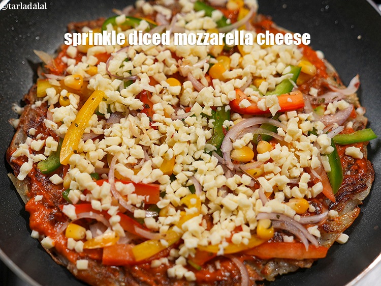 Step 24 – Sprinkle 2 tbsp <a href="https://www.tarladalal.com/glossary-diced-mozzarella-cheese-2805i">diced mozzarella cheese</a>&nbsp;evenly over it.