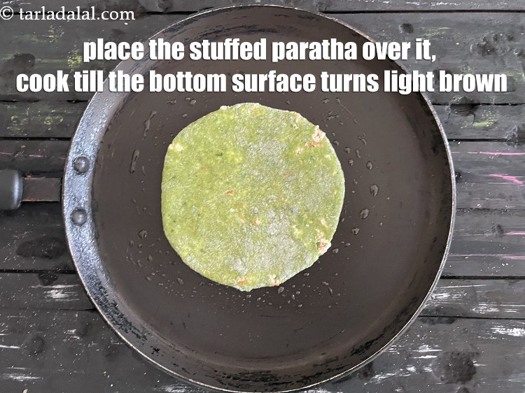 स्टेप 24 – इसके ऊपर&nbsp;<strong>भरवां पालक पराठा</strong>&nbsp;रखें ।&nbsp;नीचे की सतह हल्की ब्राउन होने …