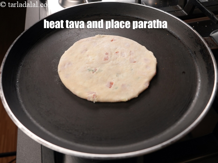 Step 24 – Heat a non-stick tava (griddle) and place the paratha.