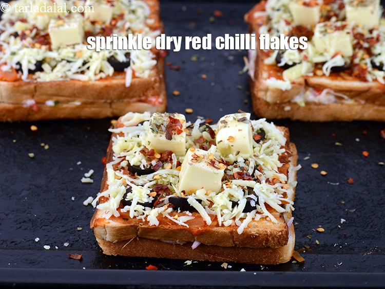 Step 24 – Sprinkle <a href="https://www.tarladalal.com/glossary-dry-red-chilli-flakes-paprika-338i">dry red chilli flakes (paprika)</a>&nbsp; evenly over each sandwich.
