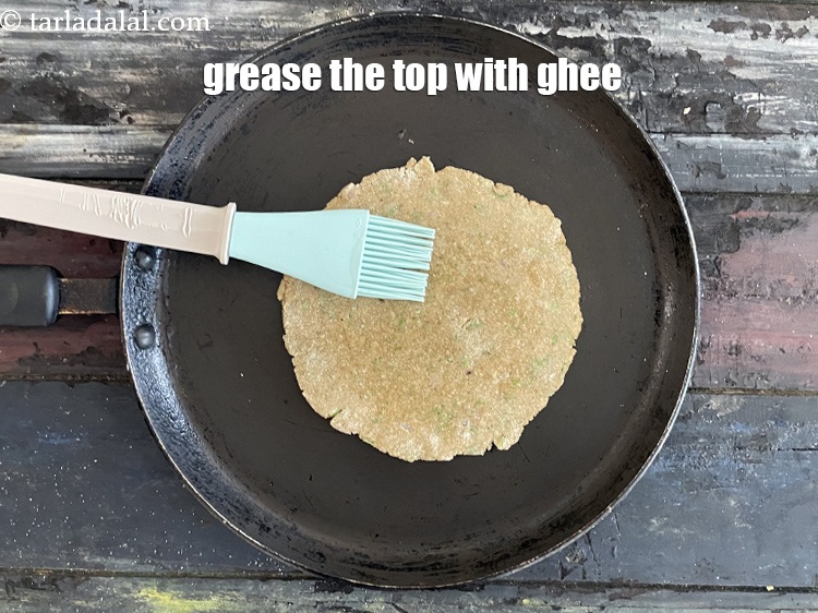 Step 24 – Grease the top of the paratha with ghee.