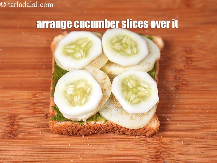 Step 26 – Arrange 4 <a href="https://www.tarladalal.com/glossary-cucumber-kakadi-kheera-321i">cucumber</a>&nbsp;slices evenly over it.