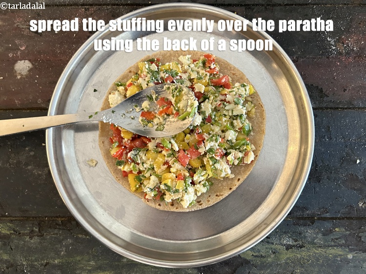 स्टेप 25 – चम्मच के पिछले हिस्से का उपयोग करके स्टफिंग को परांठे …