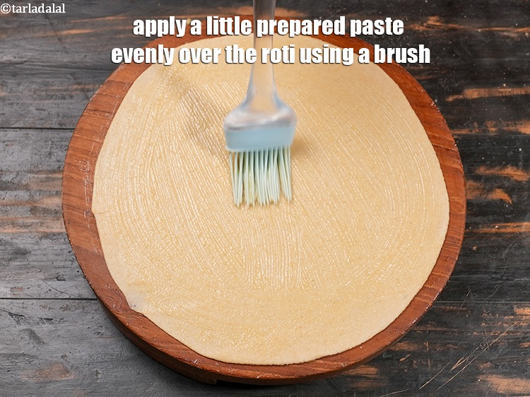 Step 25 – Apply a little prepared paste evenly over the roti using a brush.