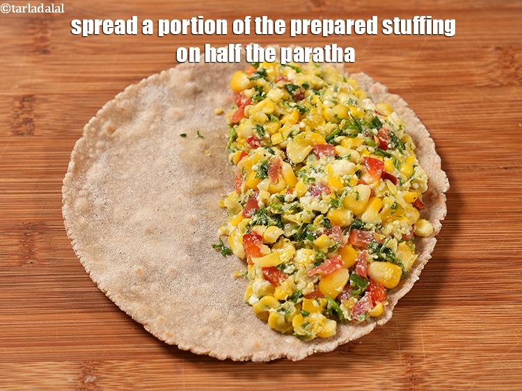 स्टेप 28 – तैयार मिश्रण का एक हिस्सा आधे पराठे पर फैलाएँ।