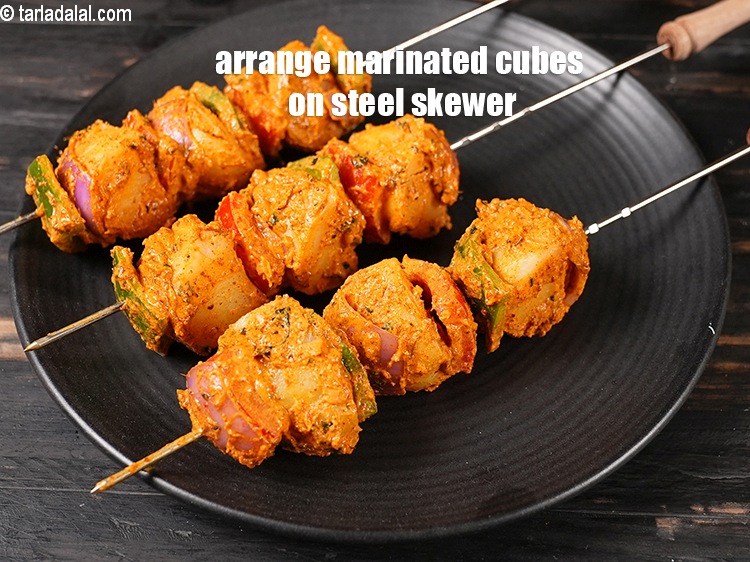 Step 26 – Now arrange the marinated onion cubes, tomato cubes, capsicum cubes and potato cubes on a …