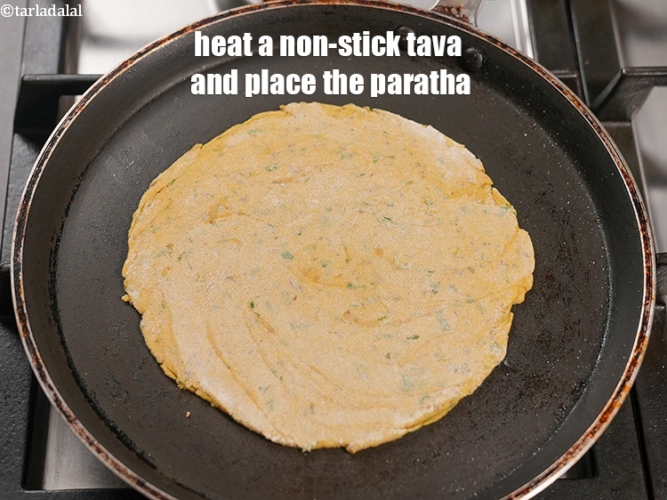 Step 25 – Heat a non-stick tava (griddle) and place the paratha.